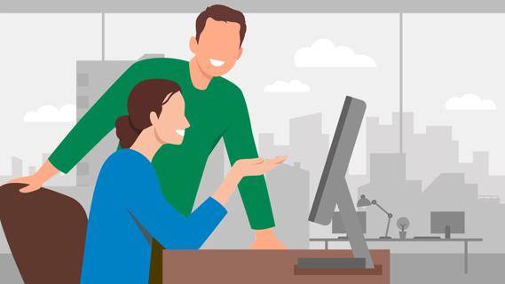 Two coworkers having a positive conversation reviewing work on a computer