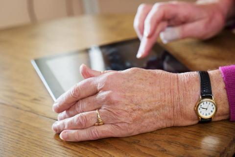 senior woman&#8217;s hands using digital tablet