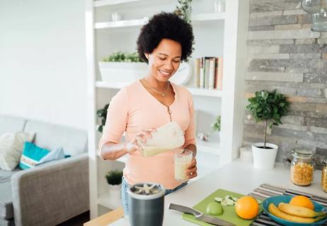 middle aged lady making herself a smoothie for personal health