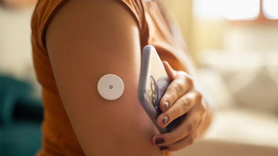 Woman checking glucose monitor