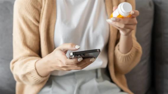Patient holding pills and phone