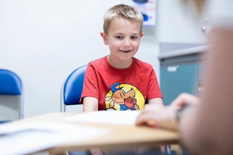 Young boy using alternative communication device