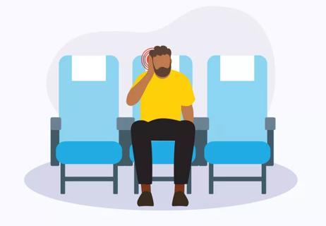 Man sitting in airplane seat experiencing ear pressure pain.