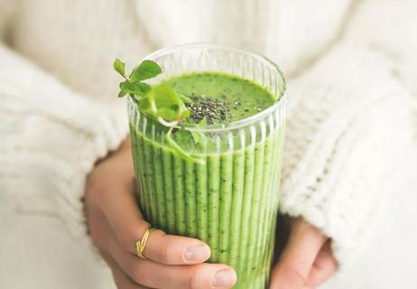 woman holding matcha smoothie