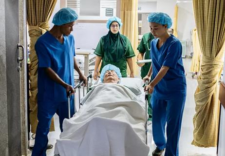 Medical team pushing hospital bed down corridor