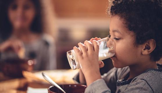 Child drinking a glass of milk at breakfast