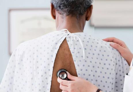 Physican listening to patient's lungs via stethescope.