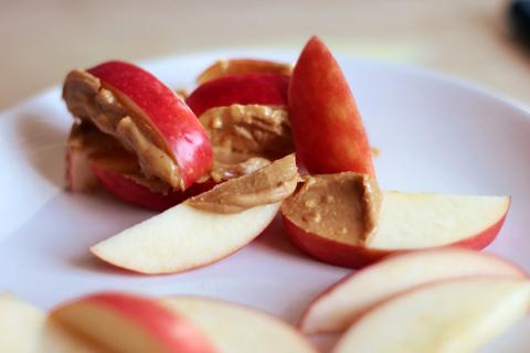 Slices of red apple with a nut butter on some of them