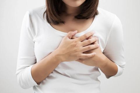 Person with both hands clasped over heart on their chest