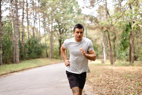 Man jogging/running on concrete path in park