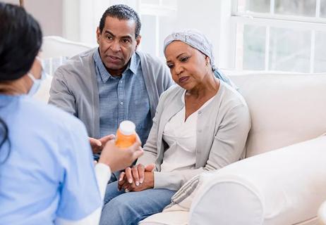 Patient and spouse listening to nurse about chemotherapy pills.