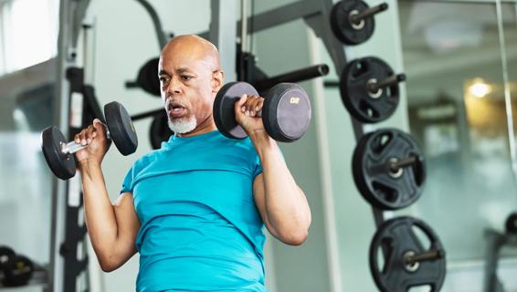 Older person lifting dumbbells at gym