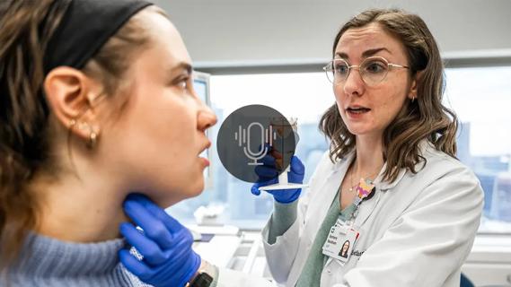 Physician working with patient on vocal techniques