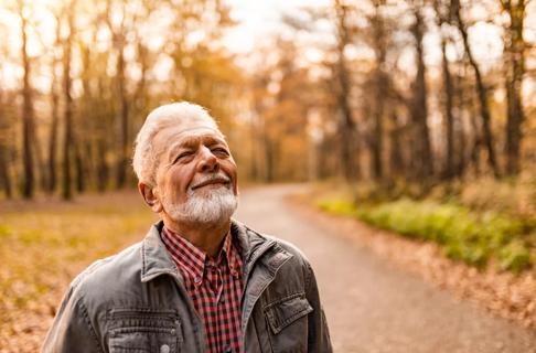 Older person smiling, taking in the outdoors