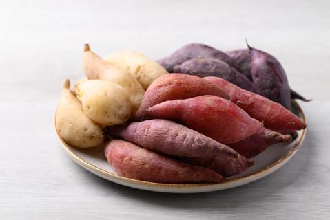 Variety of raw sweet potatoes on a plate