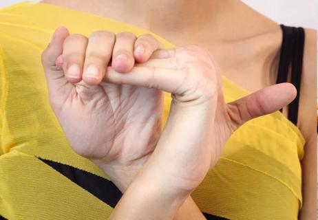 Woman folding fingers back on hand showing her flexibility