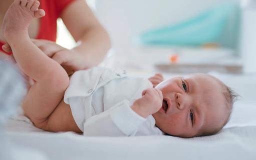 Caregiver changing newborn baby's diaper