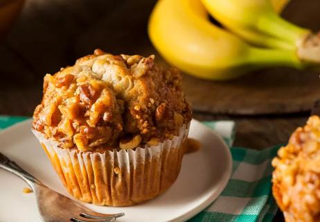 Banana nut muffin with bananas in background
