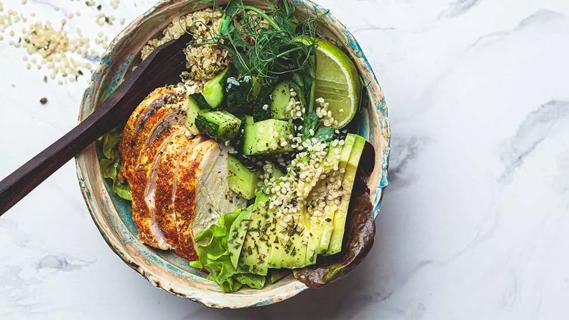 bowl filled with roasted chicken, avocado, quinoa, pickles and herbs