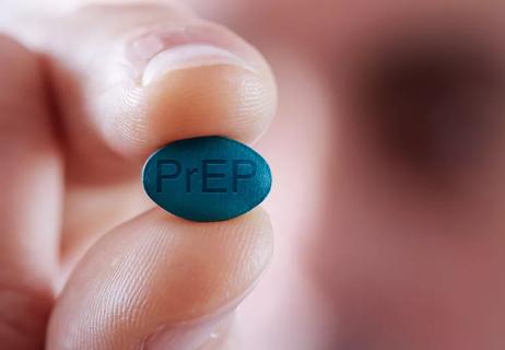 Hand holding blue PrEP pill