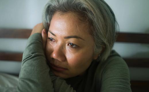 Woman leaning on arms, staring blankly ahead