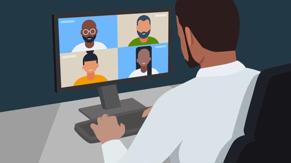 Person sitting at desk, on the computer for a team call, with call participants on the monitor