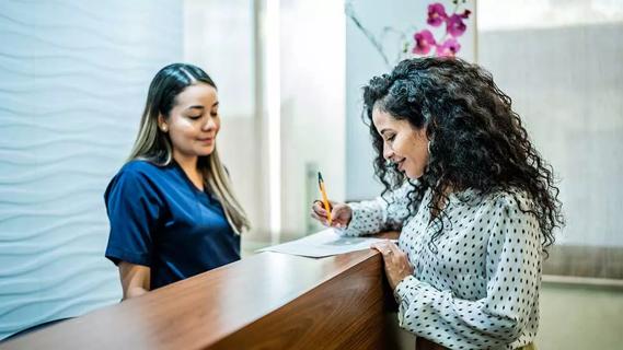 person filling out paperwork at medical office