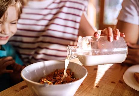 pouring milk onto son's cereal