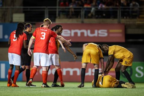 Collapsed athlete on field with team