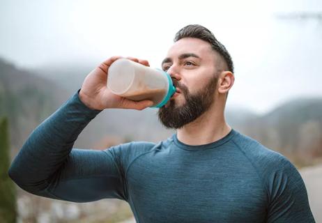 Person drinking protein drink after workout.