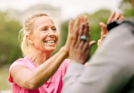 Happy older woman high-fiving her friend