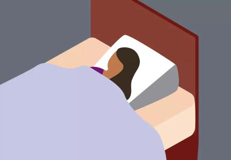 Person sleeping in a bed using a wedge pillow.