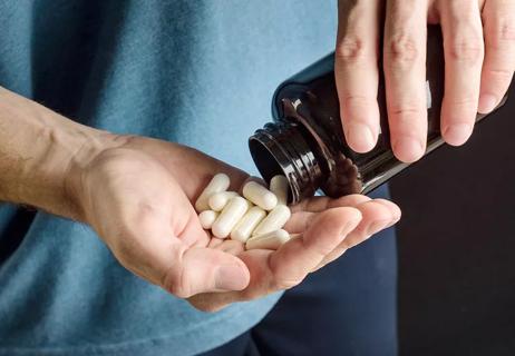 Athlete pours capsules of citrulline into his hand.