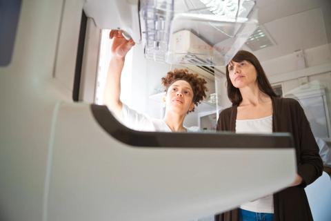 Healthcare provider showing patient how a mammogram machine works