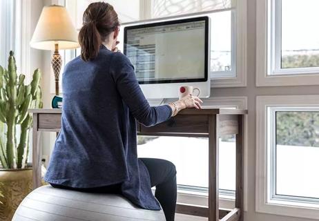 Person working from home, sitting on an exercise ball.