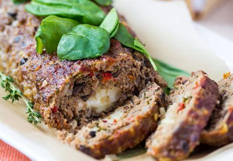 A log of sliced turkey meatloaf with baked root vegetables