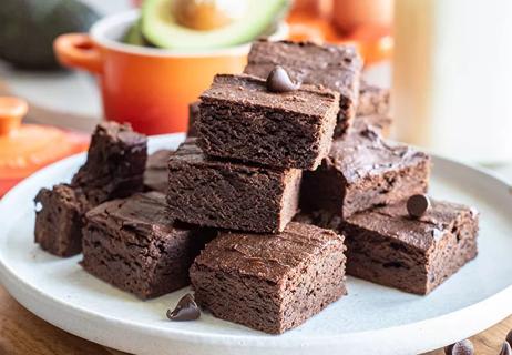 Stack of chocolatey brownies on a white plate