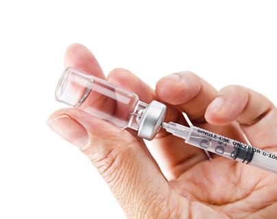 Hand holding a syringe