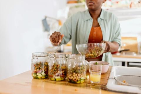 Person prepping mason jars with meals