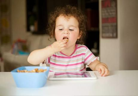 Child on ipad eating snack