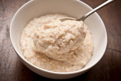 Small bowl of plain oatmeal, with spoon in it