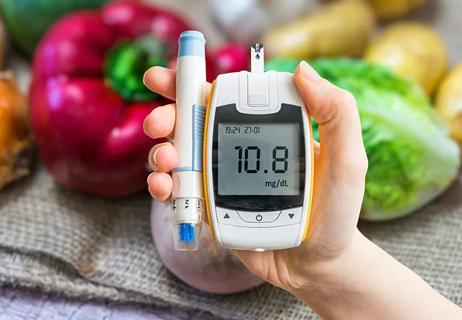 Individual holding a blood glucose monitoring kit