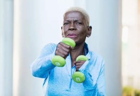 elderly woman uses weights for resistance training
