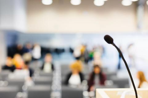 stock image showing audience and microphone at podium