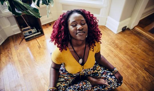 Person relaxing in a seated yoga pose at home