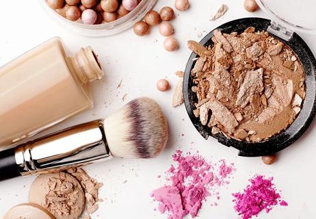 A birds-eye-view of a crushed makeup and a makeup brush