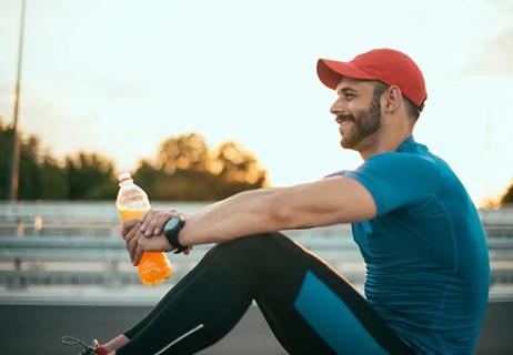 person taking a break from exercising with sports drink