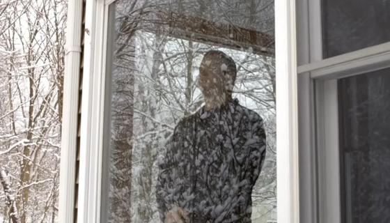 Man looking out window