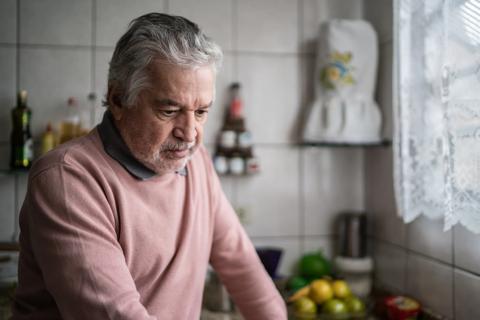 Man in kitchen, staring into space
