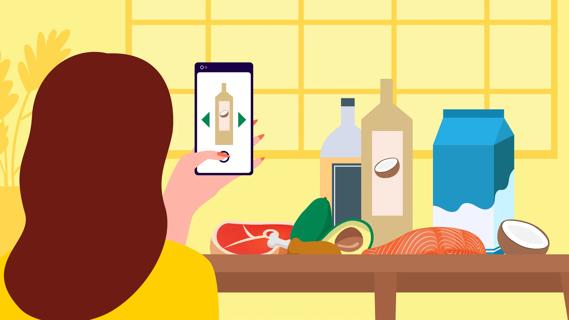 Person looking at phone for saturated fat food items that are also on the kitchen table.